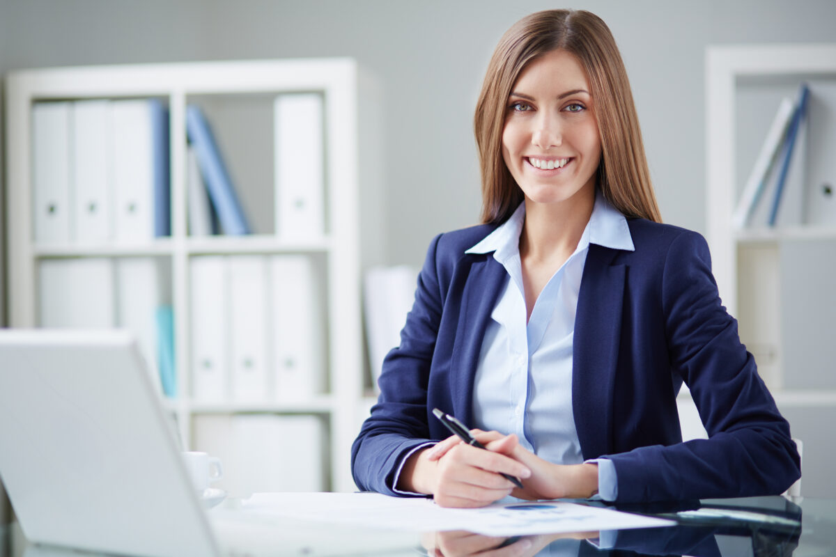 Une télésecrétaire professionnelle souriante dans un bureau médical moderne.